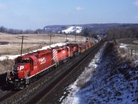 CP5735-CP6030-CP6034 lead train 507 around the Niagara Escarpment approaching Guelph Jct on Feb 16th 1995. If you nicely asked the owner of the horse farm he would allow you to drive on his property to get to the wooden bridge for this shot. 