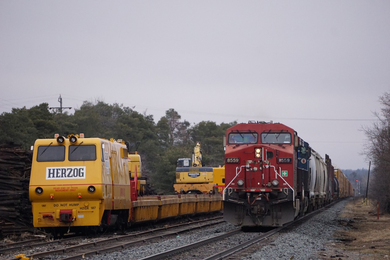 As 147 sits in Ayr waiting to get into Wolverton Yard, it's parked right beside the Harzog Tie Train unloading ties.