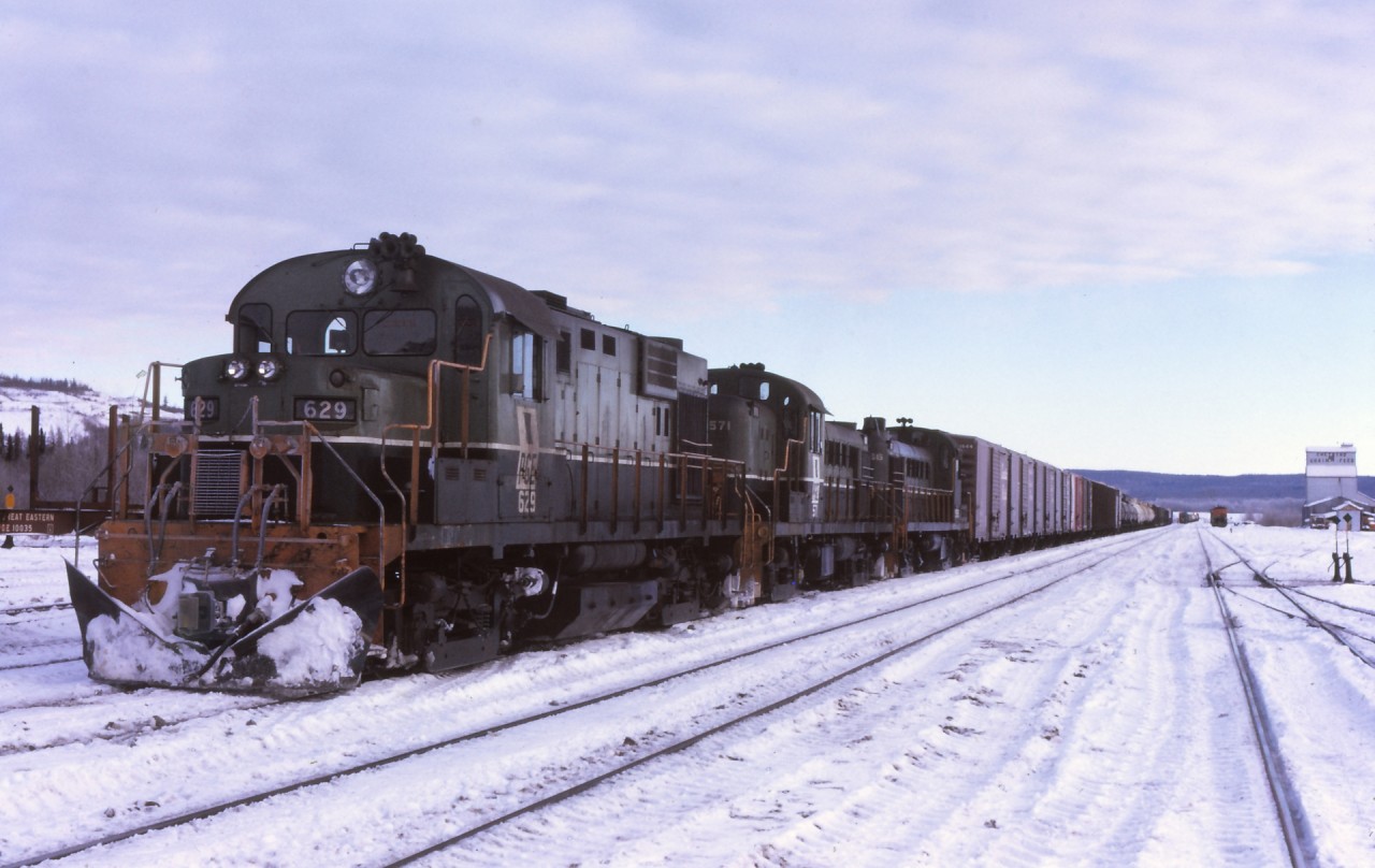 December 1973 the Fort Saint John has arrived back at Chetwynd BC after an all night trip to Fort Saint John and return. The John Turn left Chetwynd every evening north bound, setting off empty tank cars at Taylor and proceeding along to Fort Saint John. The crew would wye the power, build their south train and quite often take a meal break. Proceeding south with various loads of wood products, grain and other cargo, would stop at Taylor and pickup various loaded tank cars of petroleum products from the refinery there. After departing Taylor, the train would cross the Peace River and then the grind up a two percent grade to Septimus and then on to Chetwynd. The trips quite often were twelve or more hours on duty.