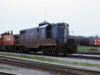 Leased Boston & Maine GP7 1569 with CP 8149 on eastbound train First 50 at Guelph Jct. in approx. April 1974. Photos of leased power displaying green flags are not all that common.  The water tower is still standing and the Goderich yard is full of cars. There are no tracks yet to store GO equipment and no enginehouse for OSR to use. The tracks in the immediate foreground are the associated connecting tracks for the Hamilton Sub. and the various yard tracks, where fans have stood for decades. Green flags, under the older Uniform Code of Operating Rules, indicated that there was (at least) another Section of this timetable train to be operated. 