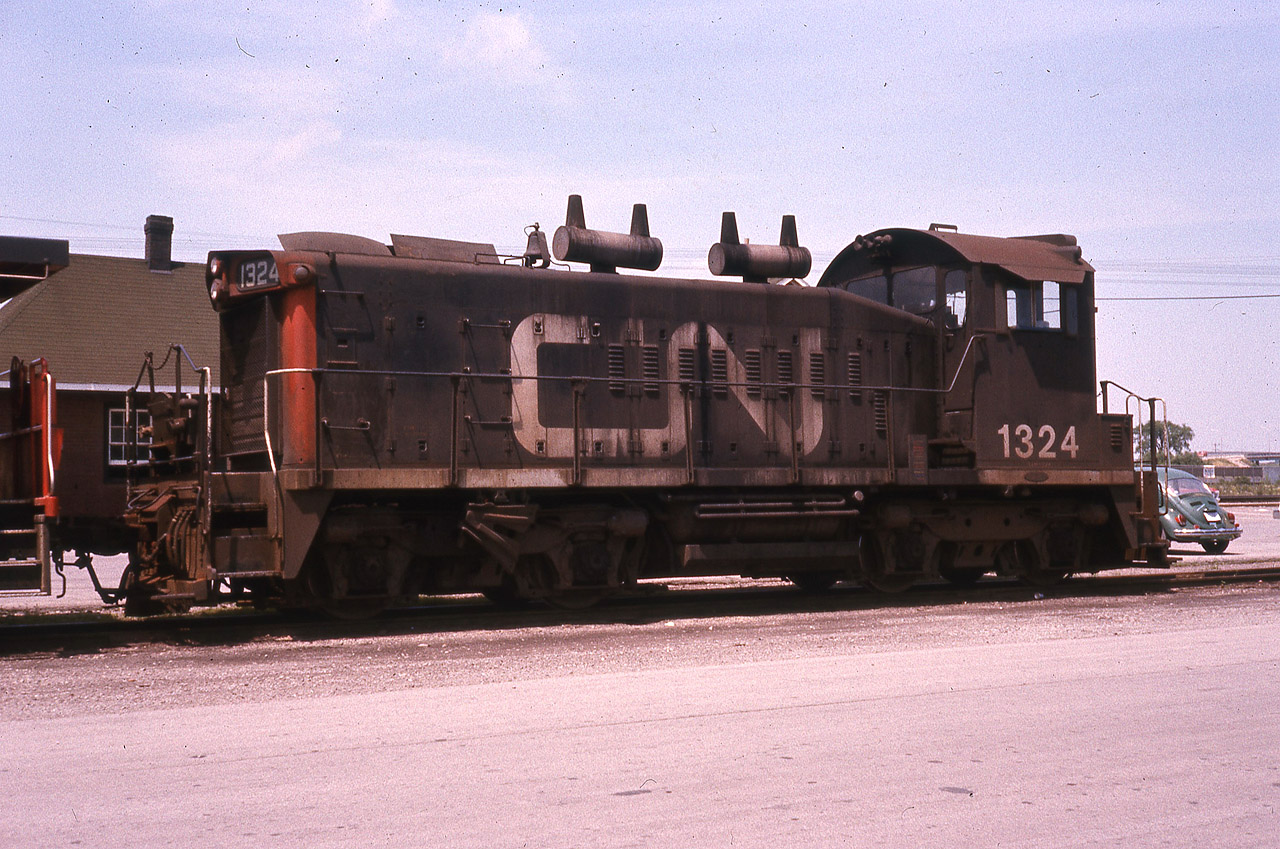 CN 1324 idles away behind the Burlington, ON station on this warm June day in 1976. Sad that only a couple of these CN SW1200's are still in use today in Ontario.
