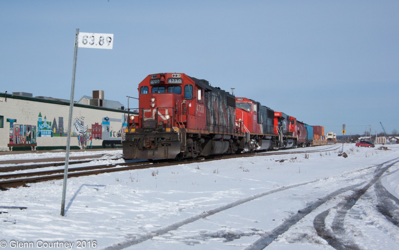 It looks like #120 must have had a problem somewhere during the night and picked up a GP38-2 somewhere along the way. It has slowed for the permanent slow order through Truro as it passes by the site of the former station, long ago replaced by a mall. On the bright side the mall afforded a canvas for a nice passenger train oriented mural parts of which can be glimpsed here.