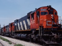 CN 208 and 308 were always favourites of Montreal-area fans back in the 1980s. They normally had three MLW "big C's" and arrived in the morning--perfect for shots on the West Island and the South Shore. (In fact, since the trains changed crews at Turcot, you had time to shoot them at either or both locations!) This morning we have 208 making its way through St. Lambert with M636/C630/M630 units "elephant style". In the background, you can see the St. Lambert station and Victoria bridge; power for St. Lambert based locals is behind the train.