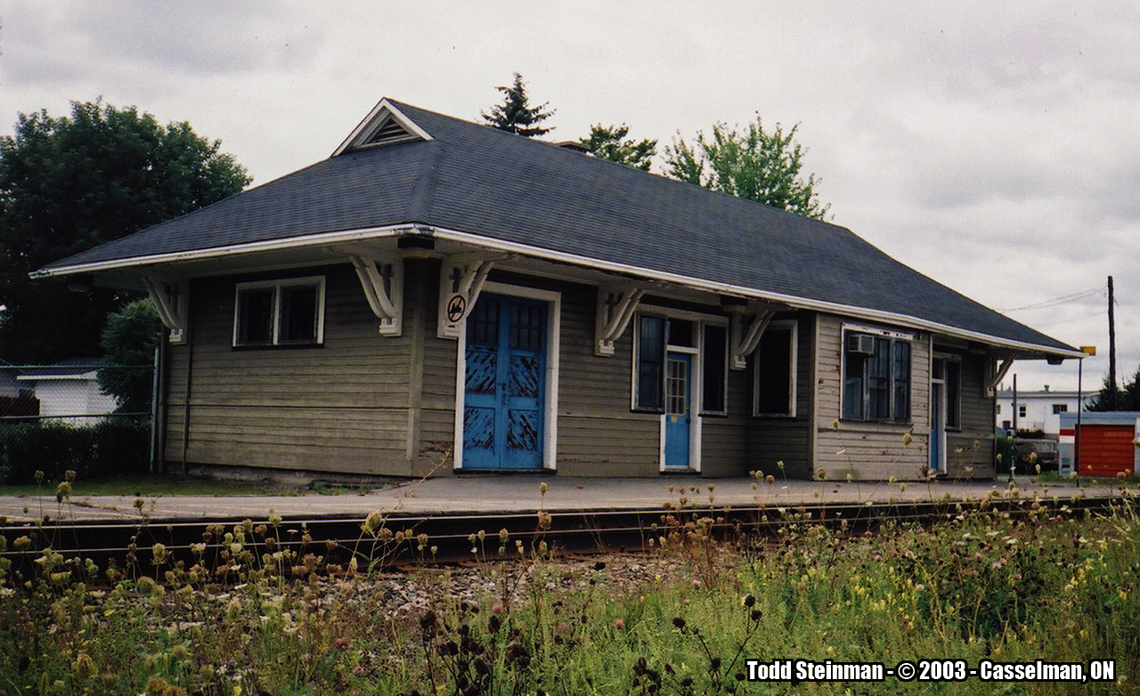 The former CN Casselman station, as seen in 2003. It wasn't in the greatest of shape, but avoided the fate of being demolished like so many other stations in the Ottawa area such as Glen Robertson, Maxville, Hawkesbury, etc. Maintenance crews were still using the station at the time of this photo, and VIA trains still stopped although they used a small shelter located just a few feet away. However, I have seen other photo's of the station posted online since my only visit in 2003. It appears it has been given a fresh two tone painting, and VIA's shelter has been removed as they now occupy the station once again.