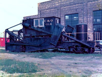 On this dreary May 1975 afternoon, C&O GL6 sits patiently outside the roundhouse in St. Thomas, ON hoping for something to do before someone decides it no longer has any use. This Jordan spreader was built around 1924 and is a standard 2-180, translating to center cab, low front blade, articulated side wings and pneumatic cylinders. It is an early front braced riveted design, and may have been rebuilt from a knuckle type unit.