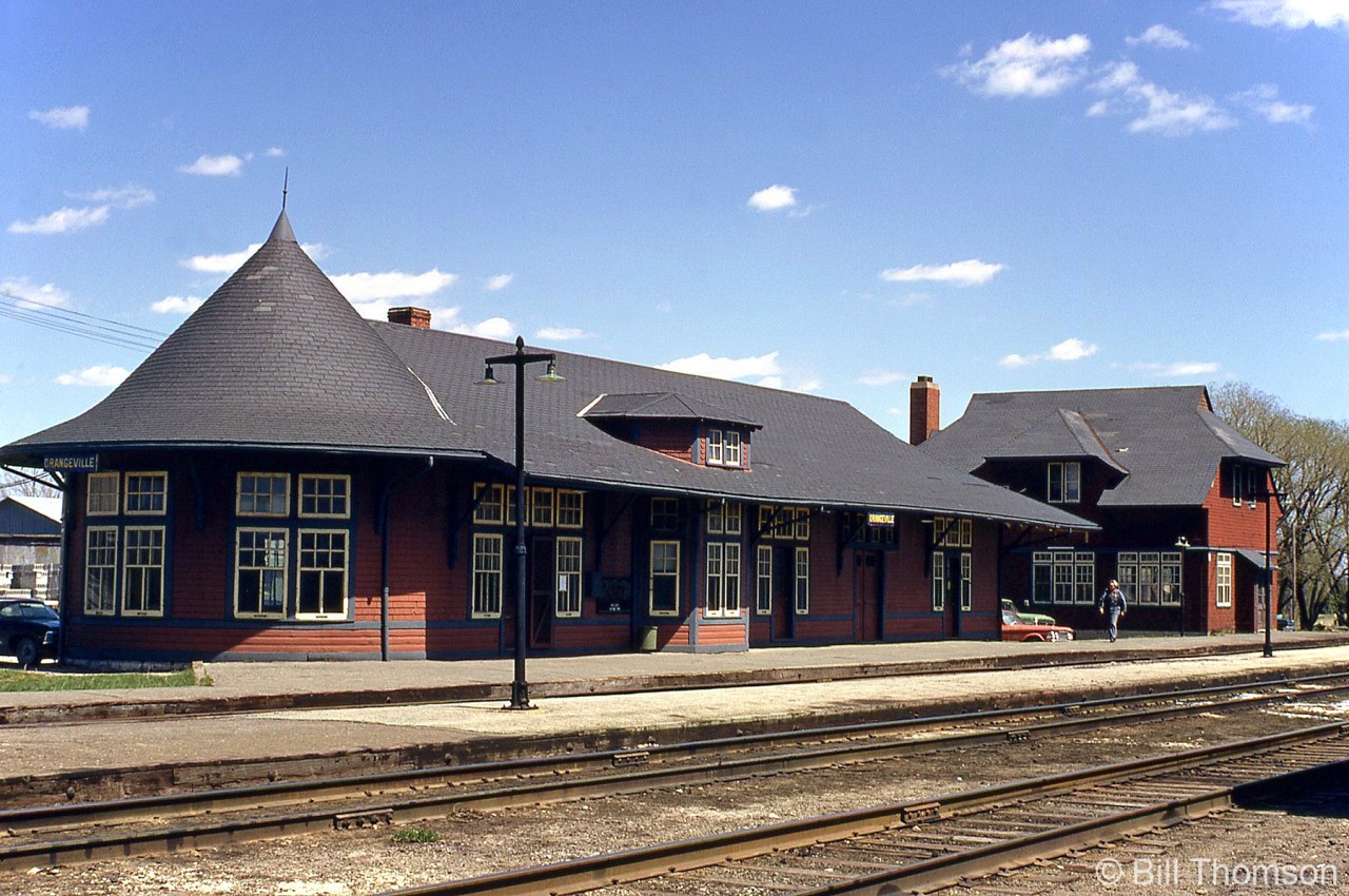 Canadian Pacific's Orangeville Station, built in 1907 and still in pristine condition, is shown next to the bunkhouse at Orangeville Yard in April 1971. It was closed and moved off-site in the 1980's to serve as a restaurant along Broadway, leaving the bunkhouse for railway use here under CP and later the Orangeville Brampton Railway.

Unfortunately the bunkhouse burned down in a fire in March 2006, but OBRY has since built its own scaled down station on site for use by the Credit Valley Explorer tourist train based out of Orangeville. GO Transit also presently uses the parking lot here for their commuter "Park And Ride" lot for bus services.