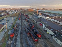 In wake of the new drone laws put in place by Transportation Minister Marc Garneau, I thought I might throw in one of those shots I knew I couldn't get away with for much longer. Sure enough, within less than a year, the drone laws became highly specific to the point that this photo would be a huge no no had I taken it with in the last two weeks. And thus, any future drone shots I may post will not be taken near cities or buildings of any kind.
<br><br>
It was just a couple days earlier I was made aware that the Algoma Central unit that had made its way into southern Ontario had experienced problems upon returning west, and was dropped off at Mac Yard. My quest was to find it since I had no photo of it, and sure enough, here it was sitting by the engine shops in Mac Yard still hooked to the widecab Geep that had led it back from Montreal.
<br><br>
Off to the far upper right is CN's deadline, which has since thinned out. Besides the four slugs visible within the yard here, I was nonetheless surprised and relatively disappointed by the pool of CN power around the yard. My younger days would recall trips near MacMillan Yard always being a treat, as the most elusive power could be found here. Whether it be a CN SW1200RS, a deadlined M630, or a high hood Grand Trunk GP9. Most of what can be seen in this shot I'm quite familiar with seeing however. Nonetheless, it was still well worth it because of the Algoma Central unit. As railroads thin their power variety out, at least the loss of drone opportunities above yards will also gradually become less significant.
<br><br>
My opinions on my disappointment of the current federal government will be kept to a minimum, but I'd like to highlight that safe drone flying can be done within relatively close quarters of people and buildings. Just like driving a car, it has to, and can be done responsibly and with care. Perhaps drone licenses could solve this issue, and loosen some of these overextensive laws? Since government sees drones only with eyes of irrational fear however, the drone community would probably be lucky if the laws did not become even more strict.
