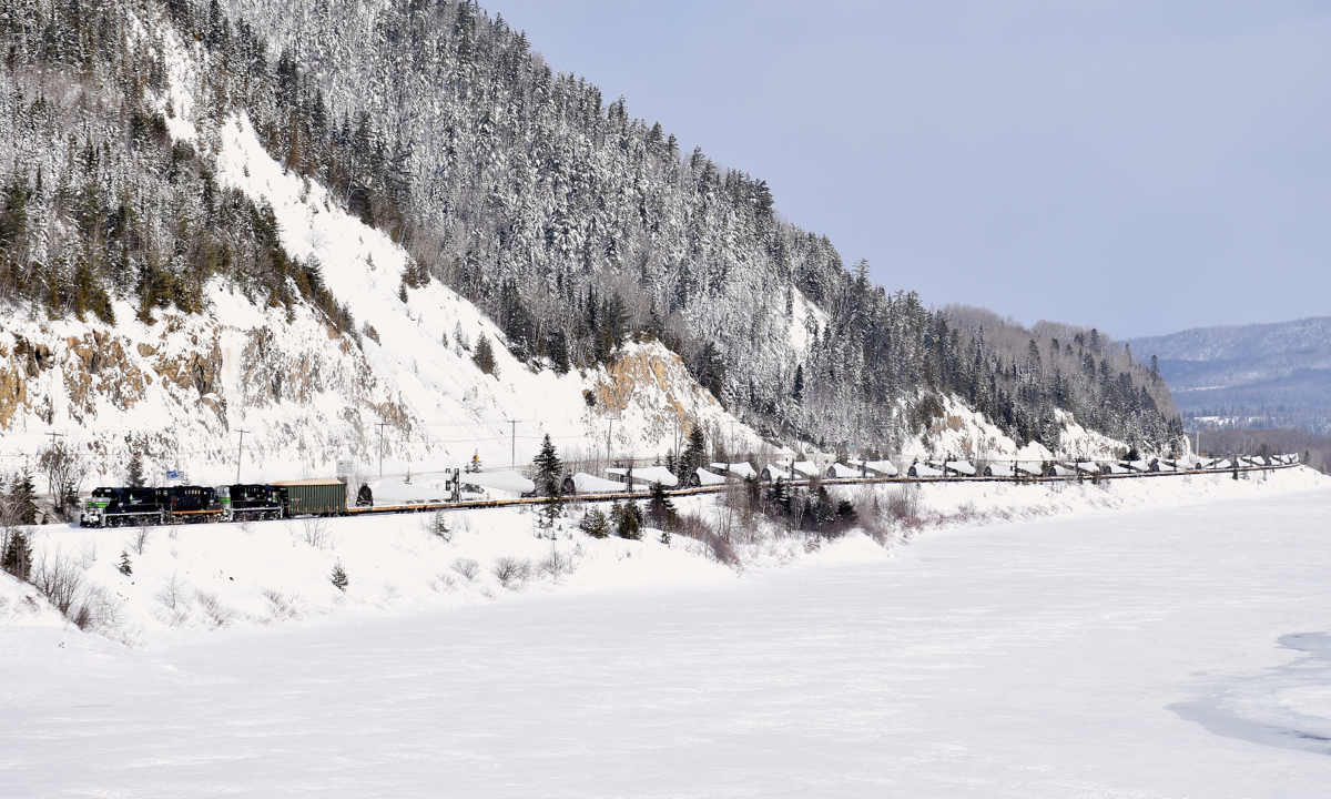 The Société du chemin de fer de la Gaspésie's windmill train slowly snakes along the Restigouche river, near its terminus of Matapedia where interchange with the CN will take place.