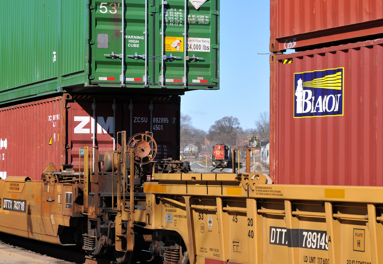 580 making a move deep within the Brantford yard, as seen through two passing well cars on CN train 148