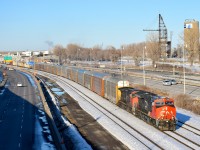 <b>22 years apart.</b> GE locomotives built 22 years apart (ET44AC CN 3068 built in 2016 and Dash9-44CWL CN 2505 built in 1994) lead Joffre Yard-Taschereau Yard CN 401 towards Turcot West, with autoracks at the head end as always (with Mercdes-Benz's from Europe). In the background along the banks of the Lachine Canal is the Lasalle Coke crane, which was used to bring coal from boats to the LaSalle Coke factory.