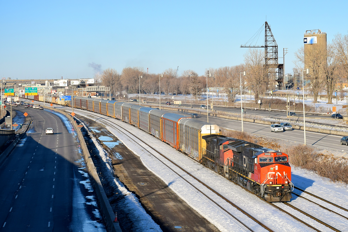 22 years apart. GE locomotives built 22 years apart (ET44AC CN 3068 built in 2016 and Dash9-44CWL CN 2505 built in 1994) lead Joffre Yard-Taschereau Yard CN 401 towards Turcot West, with autoracks at the head end as always (with Mercdes-Benz's from Europe). In the background along the banks of the Lachine Canal is the Lasalle Coke crane, which was used to bring coal from boats to the LaSalle Coke factory.