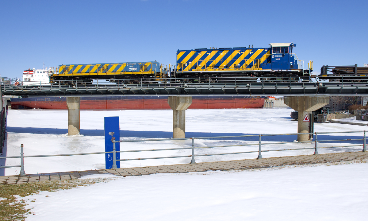 A rare move. Slug POM 2008 and RP20BD POM 1003 are stopped over the Lachine Canal with a short train consisting of lengths of rail on CP flatcars and loaded coil steel cars. This is a rare move, as they are on the CN Wharf Spur (and not Port of Montreal trackage). This is the first time I have ever seen a Port of Montreal train in this section of the port. The train would depart after port security showed up and flagged the nearby crossing. Behind the power is the Algoma Equinox.