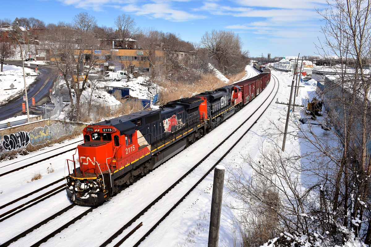 CN 2115 is looking very clean as it teams with CN 8848 to bring a 98-car CN 393 through Montreal West the day after Montreal got a decent amount of snow. On the long hood of CN 2115 is an illustration commemorating the 15th anniversary of CN being privatized, which took place in 1995.