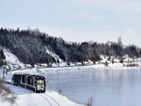 <b>Snaking along the Baie des Chaleurs.</b> Going through a 10 mph section of track, the Société du chemin de fer de la Gaspésie's windmill train slowly snakes along the Baie des Chaleurs, on its way to Matapedia and interchange with the CN. Leading is rebuilt RS-18 SFG 1819.