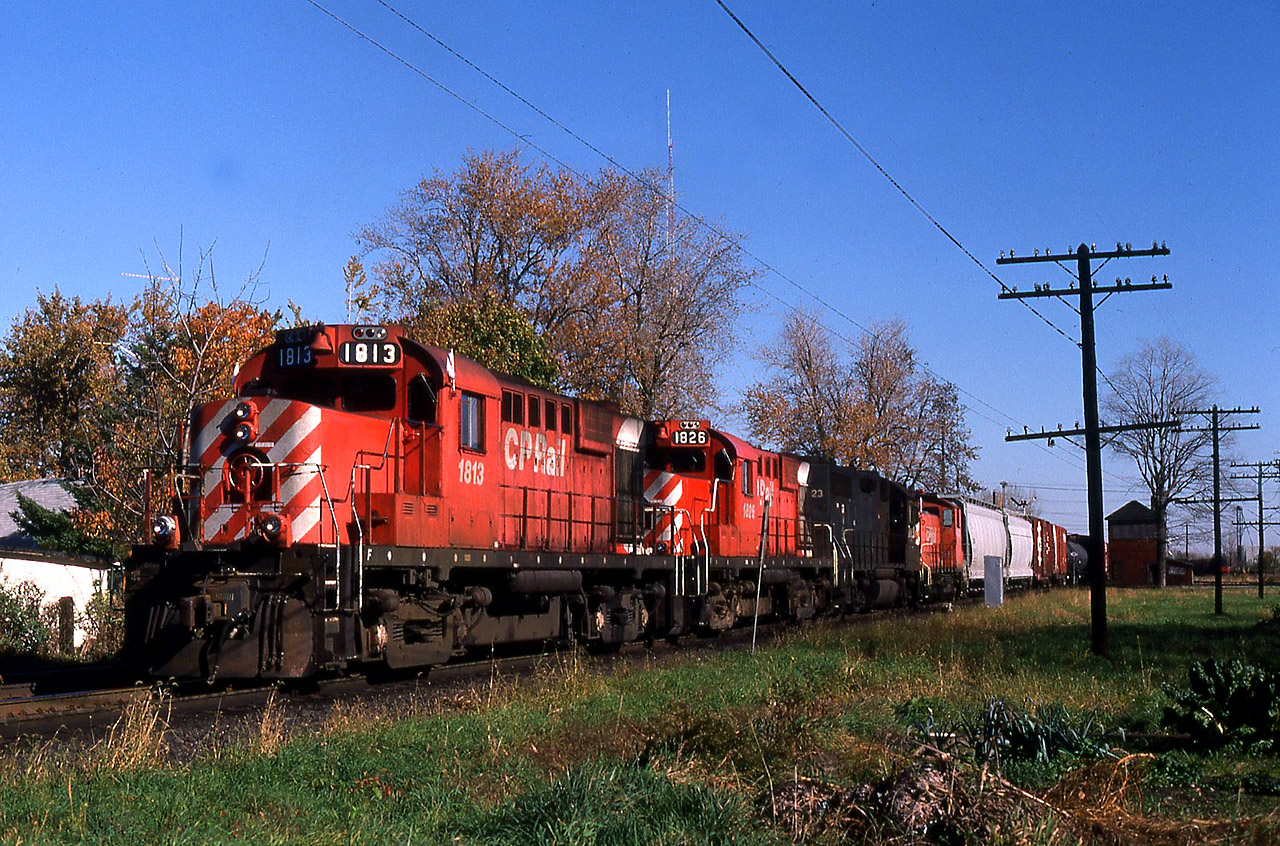 On a cool clear October morning, I was spending time trackside until my C&O assignment went to work at 1600. I had been over at the C&O station to check on how many cars our job, Local 3 the Courtright Turn would have, when the yard foreman told me there was a CP westbound getting close and he had a southside set-off. So I walked around the block and waited for this guy to show up. RS18u's 1813-1826 with leased Conrail GP38 7823 and idling CP 8153 ( for Windsor use) were pulling ahead to allow the trainman to make the 'cut' on the set off. The old CPR interlocking tower was still standing, with it's wood and insul-brick rotting away. The CP train order signal can be seen above the 3rd car, set for "Y" in both directions. At one time this interlocking was named East End. When the old tower was removed from use, with it's rods and levers, the diamond was then controlled in the concrete block structure which is on the north side of the Windsor Sub. To the left of the nose of 1813 is the C&O's Dover spur which serviced a few customers along Colborne and William Streets (Cash & Carry lumber and Dover Flour Mill).