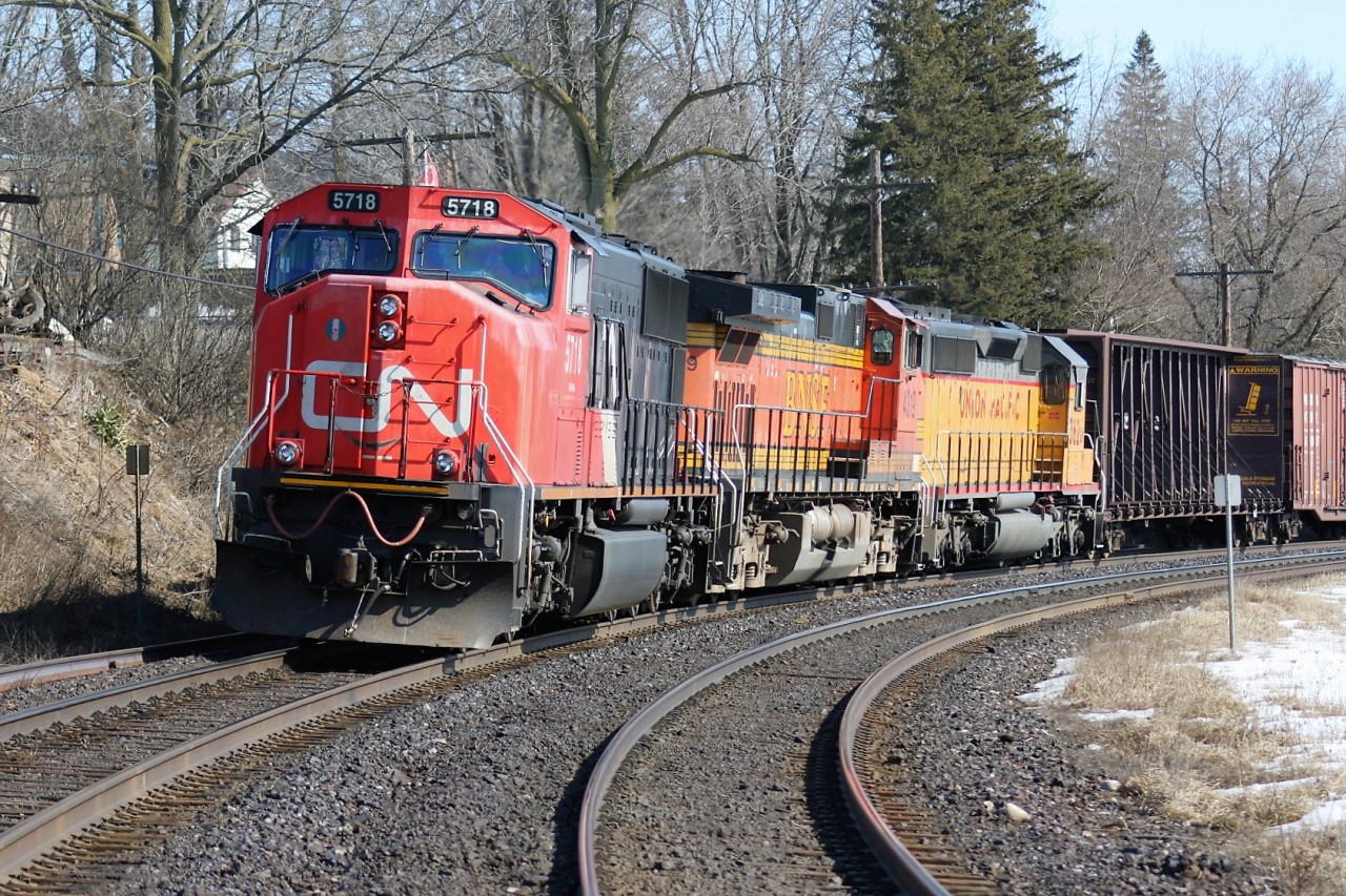 A westbound CN train is seen awaiting a fresh crew at the Broadway Street crossing in Paris, Ontario to the delight of several railfans. The consist includes SD75I 5718, BNSF C44-9W 4319 and Union Pacific SD40-2 3620.