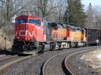A westbound CN train is seen awaiting a fresh crew at the Broadway Street crossing in Paris, Ontario to the delight of several railfans. The consist includes SD75I 5718, BNSF C44-9W 4319 and Union Pacific SD40-2 3620. 