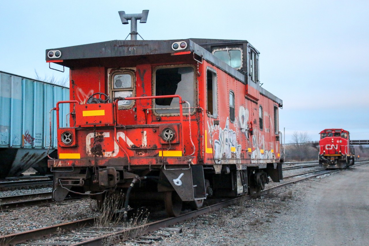 An old CN caboose #79918 sits on the track just in front of CN 9450 which sits idle after finishing work for the day in and around the Truro yard