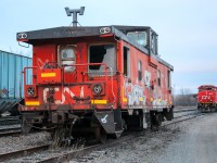 An old CN caboose #79918 sits on the track just in front of CN 9450 which sits idle after finishing work for the day in and around the Truro yard