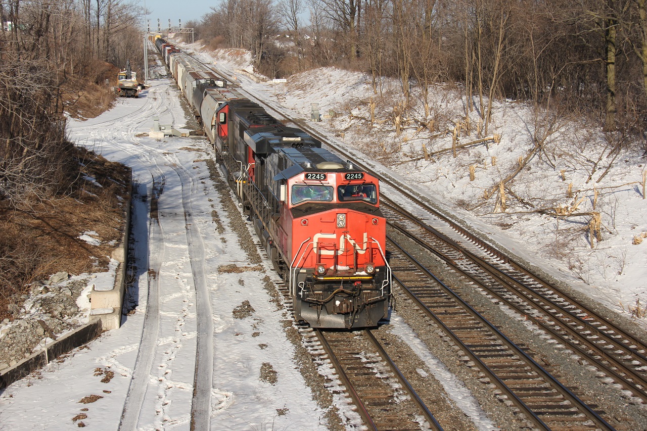 CN 435 with CN 2245 and IC 1008 (in CN paint) head west under welcomed sunny March skies at CN Snake.