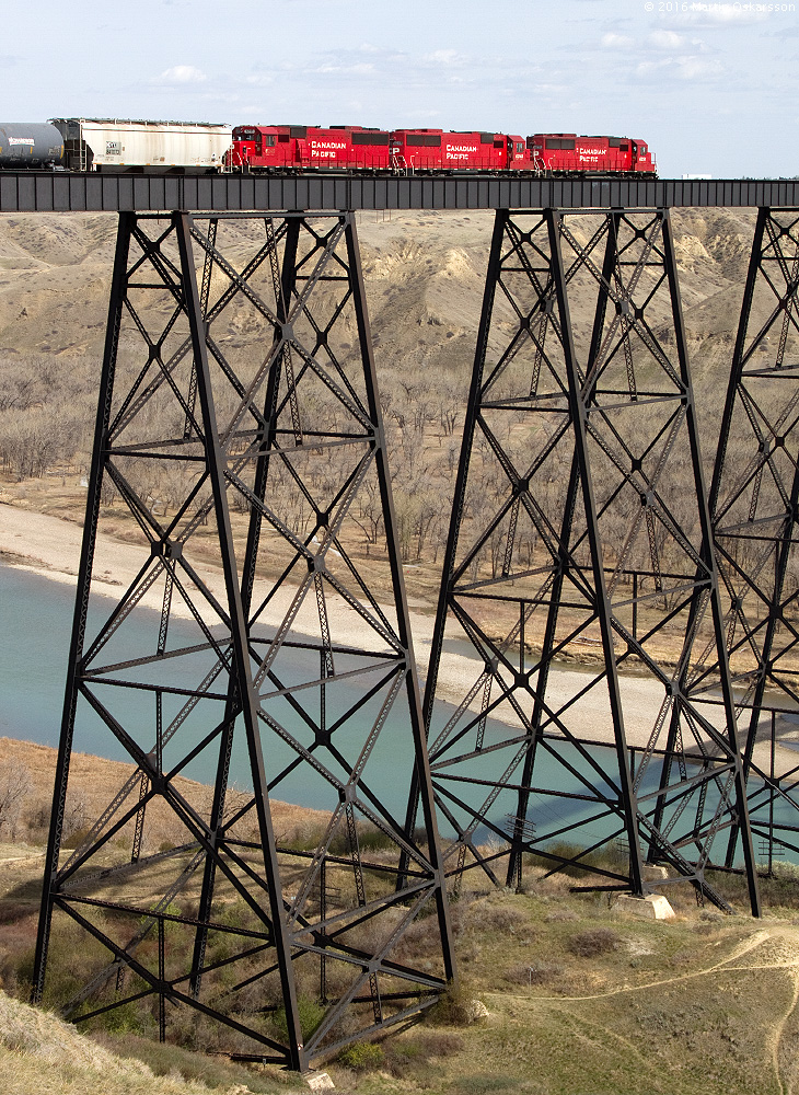 Three SD60 lead a train east across the massive bridge in Lethbridge, Alberta.