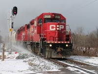 The Toyota to Wolverton local heads east through the snow flurries at Gobles Road crossing. It blew up enough wind and snow to send my hat flying into the farmer's field.