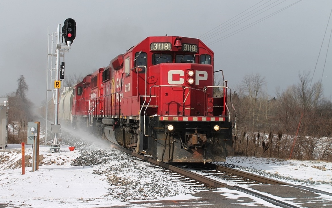 The Toyota to Wolverton local heads east through the snow flurries at Gobles Road crossing. It blew up enough wind and snow to send my hat flying into the farmer's field.