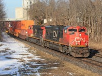 The eastbound intermodal seen to the west of the station and starting its climb up the bank. Over a third of the train had unladen well cars.