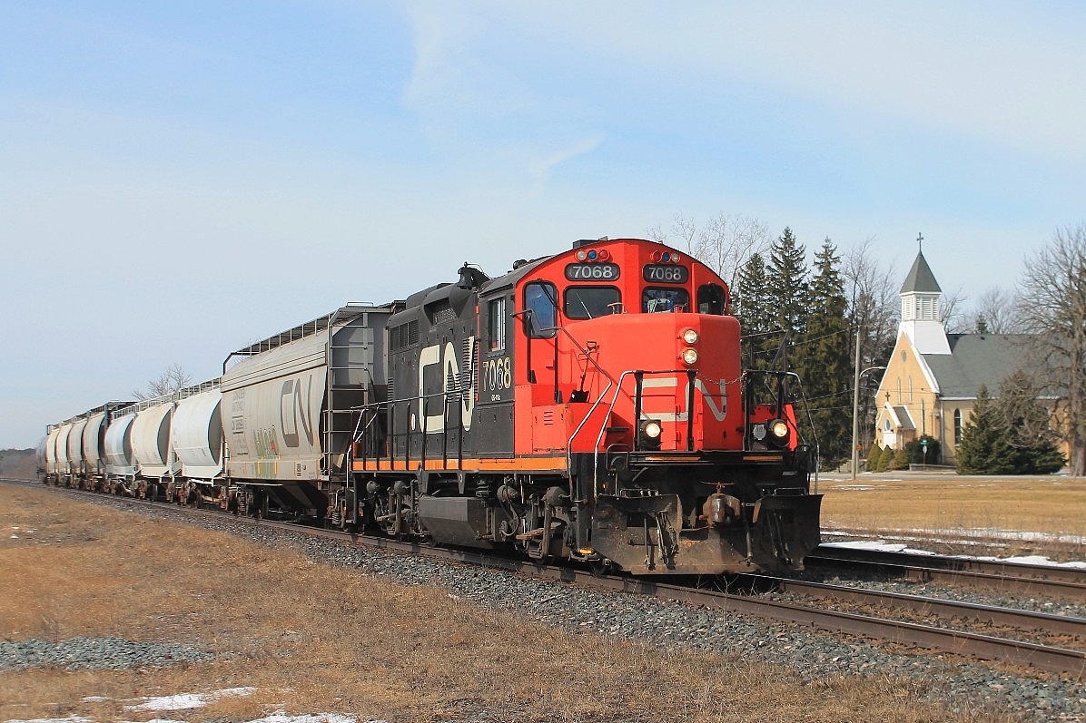 The eastbound local stopping to switch cars at the Stubbes' Cement plant next to the crossing.