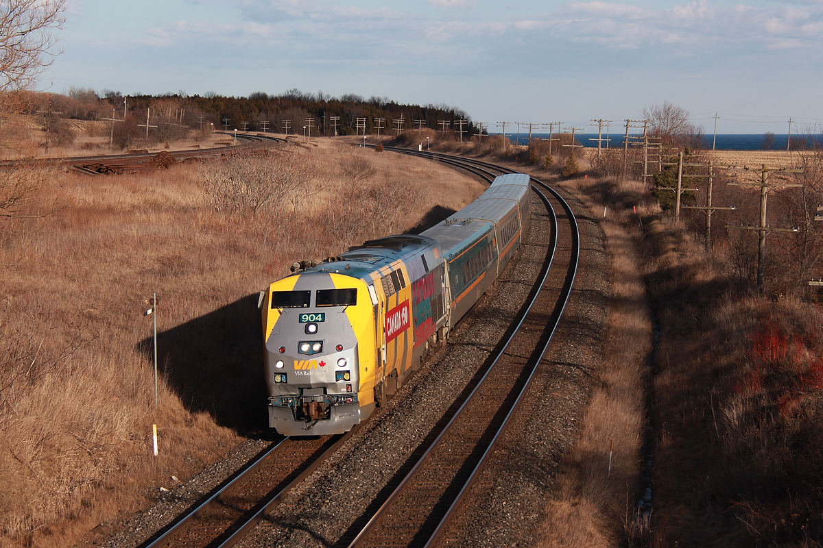 I look back through my photos, and it turns out I don't have a single photo of a Via Rail P42DC. Calling Niagara home, Via P42's haven't roamed those rails since 2012, before I even had a DSLR. This rather funky looking wrap isn't how I'd like to start off, but I guess you gotta start somewhere. While I am not a fan of it, I definitely see potential in a future Via Rail stealth scheme with solid grey and yellow.

A trip east into longitude 78 was overdue. In my younger days, my papa would take me to Newcastle to watch Via trains whip through the curves here at 90mph. I can very vaguely recall the LRC units, but the biggest memory would be the P42's and their very symphonic horns. 

Here, Via 645 rips around the curve at Lovekin with 904 at the helm. To the left, dead as a doornail like usual is the CP Belleville Sub. The CN Kingston Sub was pretty hot though as it usually is. In terms of the very symphonic horns I remember, Transport Canada put a stop to that with the new beast which sticks out like a sore thumb behind the engineer's window. These horns sound more like a mutant truck from the gates of hell. I guess that gets trespassers out of the way faster...

These Via Rail 150th Canadian anniversary wraps have really sprouted up quickly. I'd see three more on the way back home. As for Lovekin, the stay here was shortlived, as the cold biting wind roaring off of Lake Ontario was pretty nasty.