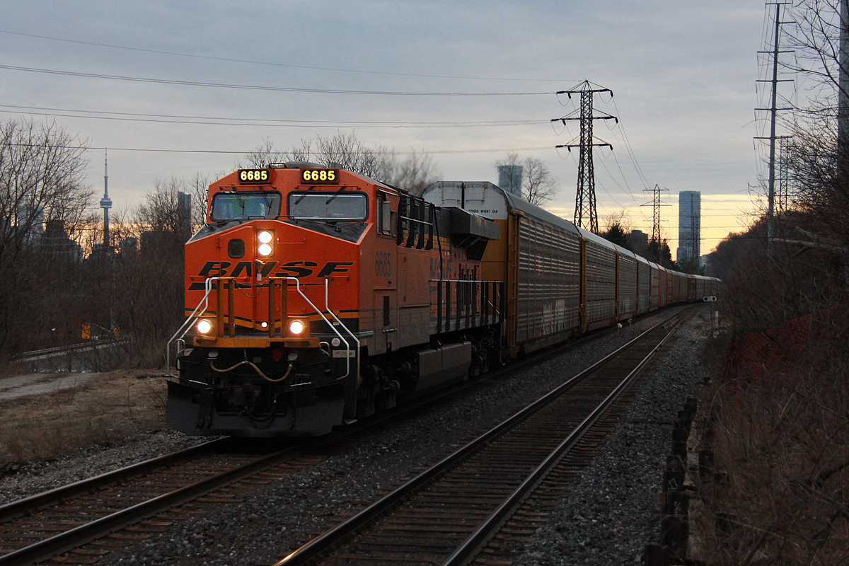 Foreign power leaders on the CP North Toronto Sub have been a relatively common thing for the last while now, however, probably 95% of that are UP leaders. BNSF leaders are rare, however, when they are seen, often 244 will fit the bill because it is typically non-stop from Wolverton so hospitality issues like hot plates or whatever CP requires that BNSF units don't have is not really a big deal for a 90 minute trip.

I found out about this train while waiting to get a picture of a GO train weaving down the Bala Sub at Pottery Road. A friend of mine gave me the heads that a BNSF leader was approaching Howland interlocking on the CP North Toronto Sub. Luckily for me that was a short distance up the road from where I was, however, the location I remembered as possible to choose from was more of a last resort. Within maybe three minutes of jumping out of the car it whipped around the bend. Lucky... Not knowing the potential of this vantage point, I was unaware that the CN Tower was largely unobstructed from view of this spot.

Alone, BNSF 6685 leads the short 15 car CP 244 through the west end of Leaside at track speed on the the way to CP's Toronto Yard in Agincourt. It took a while, but after seeing this a number of times, I finally have a photo of something other than a UP unit as foreign power leading a train in Canada. As for the GO train? Haha. Well, I was able to see it through the trees in the Don Valley on the way on the way back to my car. The anticipated L6 F59PH leader consist did not come, so in the end I guess it was a win win. Out of view beyond the road leading up to the line is the the former CP Don Branch, which if looking from this ridge would be seen clearly had the camera been pointing maybe 70 degrees to the left. There's a lot of rail infrastructure visible from this spot in the cooler months, but unfortunately both the Don Branch and Bala Subs are still heavily obstructed by trees. It's far from an ideal railfanning location sadly.