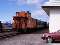 DEPARTING BISHOPS FALLS. Terra Transport Caboose 6070, built in 1967 by National Steel Car of Hamilton for CN's narrow gauge Newfoundland division, is tacked to end of Mixed Extra 945 West on April 20, 1987. Upon learning that a mixed train service still operated on the Island railway, the photographer and his then girlfriend (now wife) left the capital city of St. John's to eagerly ride what was he believed was lost forever. Next to the caboose was coach 757 in which the two were the only passengers for the entire 138 mile journey to Corner Brook on that beautiful spring day.