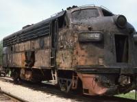 On the morning of June 10/75 N&W train DN90 suffered a broken traction motor gearcase cover while moving at track speed through Simcoe on the CN Cayuga Sub. The resulting derailment caused lead F7 3659 to plummet off the Highway 24 bridge and burst into flames, killing the crew. Trailing unit 3725 derailed but remained upright. Two days later, on my lunchhour break from TH&B Brantford office duty, I drove to the aftermath and shot 3659, after it had been retrieved from the overpass and set aside in preparation for movement.