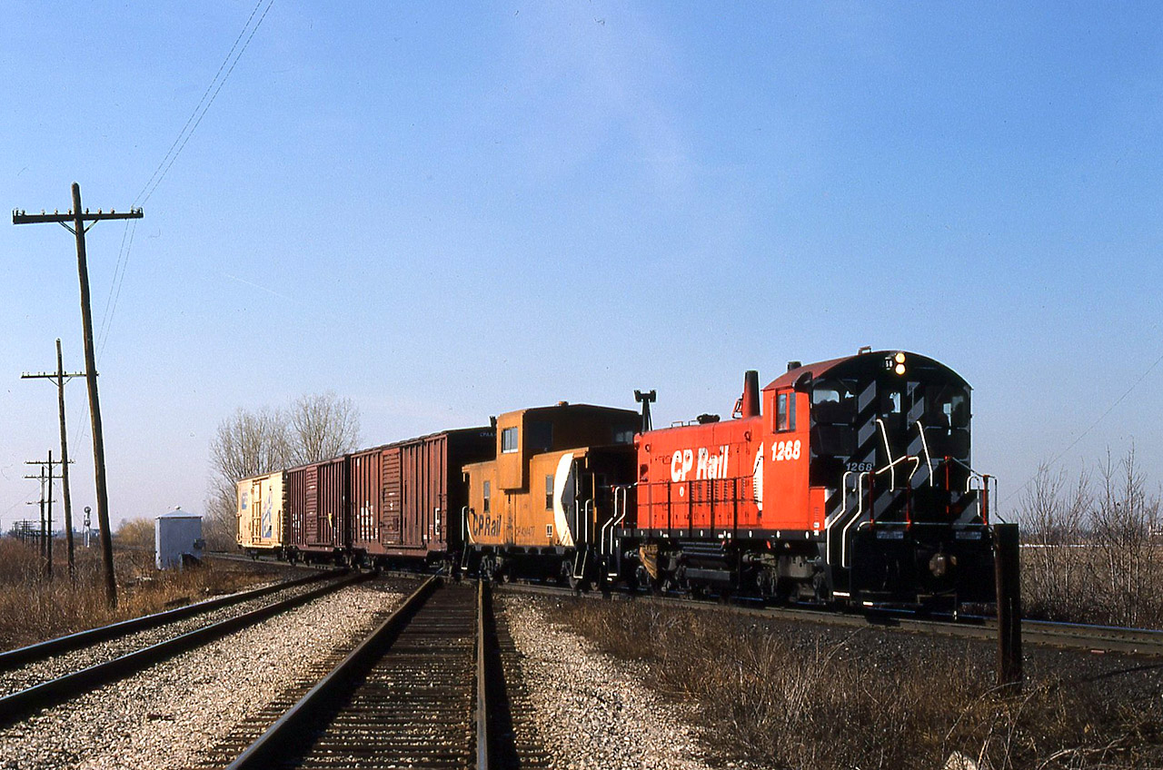 CPR had a Roadswitcher based at Chatham in the 1980s and as required, 3 or 4 days per week, it would make the trek westward to switch customers at Tilbury ( Hunt-Wesson Foods) and perhaps as far as Saint Joachim ( although I have no first-hand knowledge of that). The engineer on this job, a nice man named Maurice (---) lived beside the C&O Sarnia Sub. in Wallaceburg. He would always give us a hi-ball when we went through that town. Anyway, here's his job returning east at the diamond of the CN Chatham Sub. just west of CP Ringold siding near Dillon Sideroad. This is pretty much the normal operating procedure when heading home to tie down, having the caboose (van) next to the engine. The last car is definitely from Hunt-Wesson, one of those SOLID COLD reefers probably with frozen peas or french fries. The pole lines are still in place, the Chatham Sub. is still 2 tracks and 1268 has yet to receive ditchlights. This engine still exists today, living a sheltered life at Unimin Corporation in Hephzibah GA.