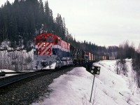 March 16 1985, BCR 722 freshly painted and overhauled,with trailing units 618-621-632, poised on Stone Creek bridge at mile 444.3 on the BC Rail Prince George subdivision. Without much delay I stopped the train for a quick photo opportunity. It was a rather dull morning and I opted to extinguish the ditch / corner lights, less confusion for the camera light meter. The bridge over Stone Creek was a "glue-lam" structure with concrete waterway underneath. Station name sign "Stoner", mileage 443.9 is further back in the train.

  As can be seen the 722 is flying white flags and white class lights, train order authority to "run extra", Williams Lake to Prince George BC. On this day we were the symbol freight "VO" (Vancouver-Omnieca). BC Rail as well ran two other symbol freights northbound daily, "VP" (Vancouver-Peace) and the "VC" (Vancouver-Cariboo) these symbolized trains served the three regions of BC Rail. During the days of train orders and time table scheduled trains the symbol VP ran as train No23 from North Vancouver to Chetwynd. The two other north freight trains ran as "extra" although for operation purposes they had a scheduled time of operation. On this particular trip pictured, we would take rest at Prince George and then return to Williams Lake on the "OV" symbol usually running as a No.38 or a late No 36 on a "fourth class" time table schedule. No 23 the VP ran as a "third class" scheduled train.