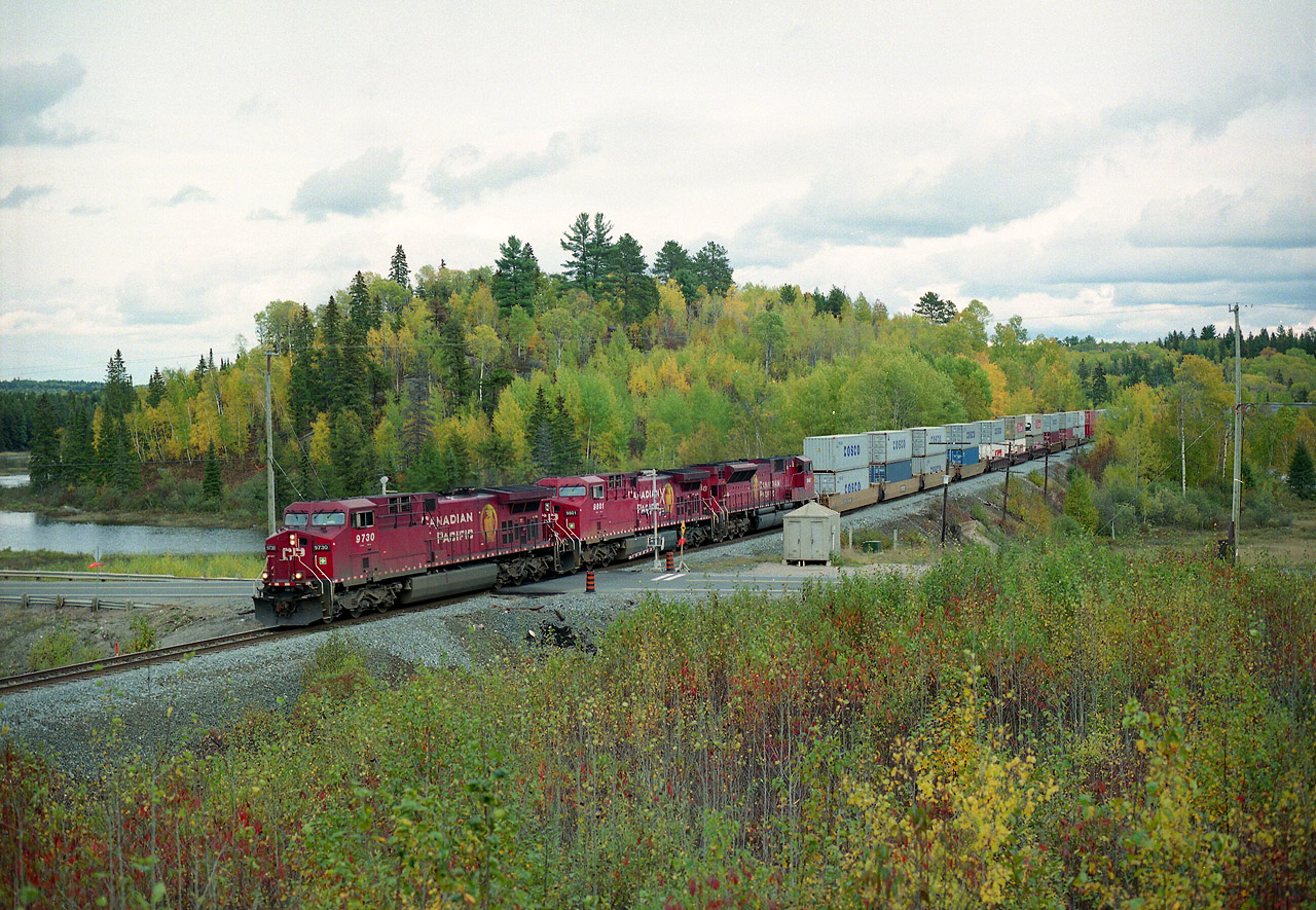 Call this a 'standard issue' shot for this location. I'm posting this for those who railfan north of Sudbury, namely out of Cartier; the westbounds out of this railroad town can be chased to the crossing at Hwy 144 with about a couple of minutes to spare without driving like a lunatic. There are several angles to shoot here, but this one gives the best open view. Just before the crossing a dirt trail can be navigated up into a small parking area and this is the resulting shot. The area appears to get a regular crew-cut, the foliage gets a manicure in the fall.....at least it used to.....This typical westbound has CP 9730, 9801 and 9148 for power. Moose are common in that swamp pond in the background. Benny? Well, it is the closest community, a gathering of maybe 6 non-descript dwellings about a mile to the north-west.