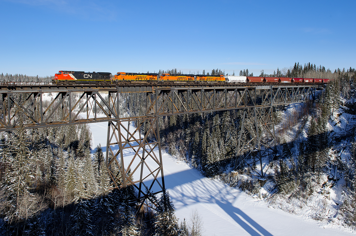 CN C44-9W 2566 teams up with BNSF ES44C4s 8355, 7190 and 4256 leading CN detour train F30541 05 across the Pembina River between Entwistle and Evansburg, Alberta. This is BNSF's G AVIKAL9 05 detouring from Noyes, MN to Vancouver, BC due to ongoing issues on BNSF's Hi-Line Subdivision in Montana.