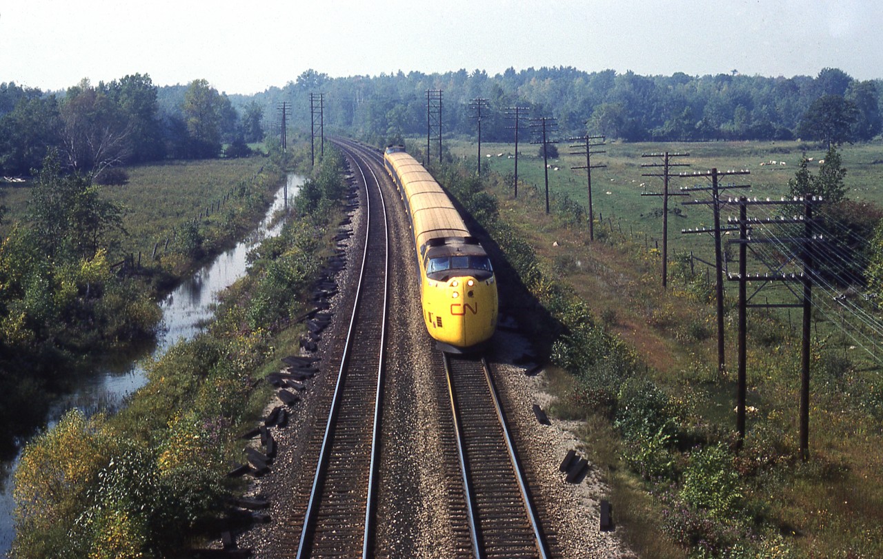 An Ollie McKee photo.
Not much to go on from the slide itself but with a little help from people that know the railroad, this appears to be at mile 101, eastbound, off the Regional Road 1 overpass. Given that Mr. McKee was a Brockville resident, this would be within his ' territory '. If anyone has a different opinion, I'd be happy to have the Editor make a correction. 
In any event, a good overhead view of the yellow worm.