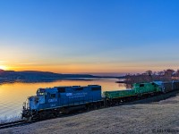 With the sun on the rise along the Saint John River Valley, GMTX 2233 leads an extra westbound 907, as they run along the Saint John River at Grand Bay-Westfield, New Brunswick. A steller lashup, with slug 008 and NBSR 2318 making up the rest of the consist of this empty woodchip train.
