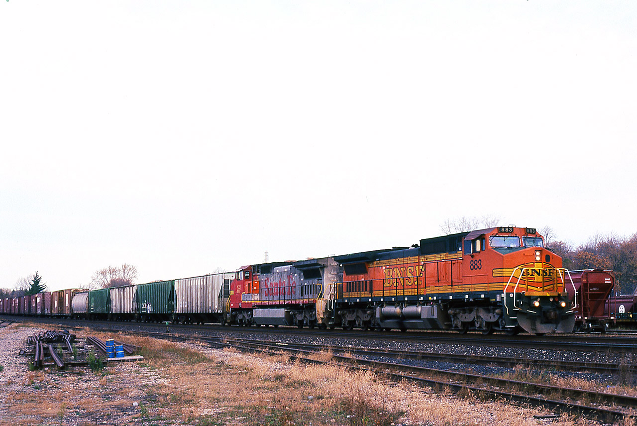 The roulette wheel keeps on spinning, as a pair of BNSF GE's 883-829 are on the point of NS St. Thomas to Buffalo train 328 passing through Brantford on a cool November morning. The existence of trains 327/328 on the NS ledger was to provide timely service for Ford's Talbotville plant. But long before the auto maker built that facility, predecessor Wabash RR had procured other on-line customers. Those covered hoppers may have come from one of several elevators along the former Paynes or Cayuga Subdivision's, or from the Thamesville elevator on the Chatham Sub.