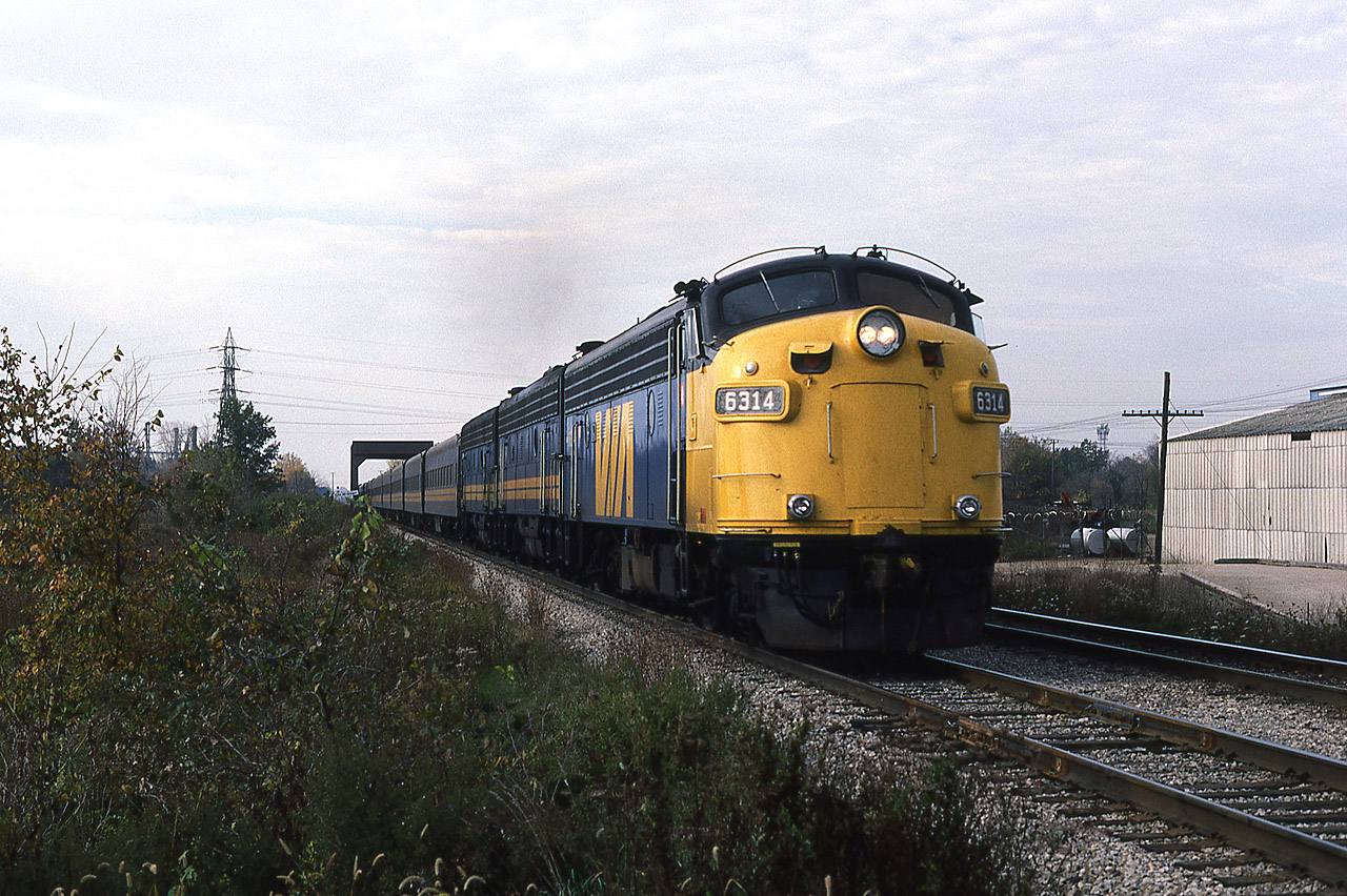 Saturday morning was a good time to catch 72 and 74 with big consists, and especially during the era prior to the delivery of the F40s. Sass Road was another location where eastbound trains could be easily captured because for the most part, the foliage was kept low. Train 72 accelerates out of town pulled by reconditioned 6314 and F9B's 6623-6636, having crossed C&O Subdivision No.2 and McGregor Creek. Every once in a while a boxcar or bulkhead flatcar would be placed on the short spur next to that concrete ramp, but I've long since forgotten what type of business was in operation at that address. The reconditioned 6300s were among the first older VIA units to have their ditchlights properly built-in, but today the hogger has forgotten to turn them back on after making the station stop.