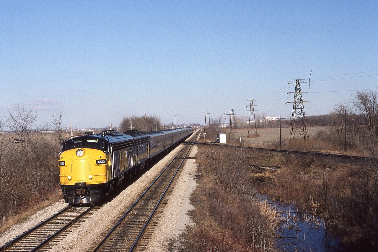 A very clean 6512 is assisted by an F9B, also quite clean, as they bring train 73 and 11 cars westward from Chatham. Wanting to get some elevation, I waited until he was in view, and then climbed to the upper perch of the eastward Absolute signal. Only one half of the old motor car pulloff is now in existence ( opposite the first coach) having been removed when the westward track was refurbished with ties in 1984. This equipment will turn at Windsor and cycle east as train 78 later in the day.