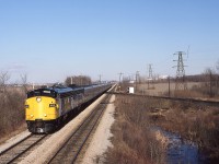 A very clean 6512 is assisted by an F9B, also quite clean, as they bring train 73 and 11 cars westward from Chatham. Wanting to get some elevation, I waited until he was in view, and then climbed to the upper perch of the eastward Absolute signal. Only one half of the old motor car pulloff is now in existence ( opposite the first coach) having been removed when the westward track was refurbished with ties in 1984. This equipment will turn at Windsor and cycle east as train 78 later in the day.