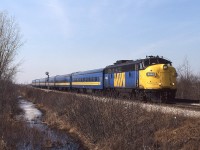 
1987 would be the final year we lived in Chatham ( in November we moved to Bright's Grove, as CSX began to alter their Canadian operations). The first group of F40PH were in service, so I had stepped up my recon activities to catch the fading fleet of cab's and boosters. Once again, on a calm sunny day, I'm at the diamond crossing of the CN Chatham Sub and the CPR Windsor Sub. Train 74 is due and when I hear him at Prairie Siding, I get into position on the Windsor Sub, so as to obtain some elevation and keep the image 'clean'. Another single unit/6 car consist in the Corridor, as the aging FP9 drifts by the Absolute signal and clatters through the automatic interlocking. Happily, this engine exists today, on the Boone and Scenic Valley tourist operation, at Boone IA painted in C&NW colours.