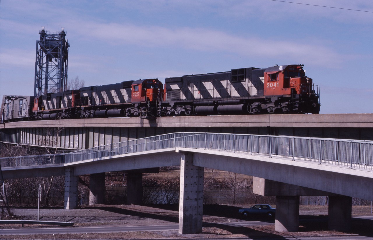 To avoid railway delays, the St. Lawrence Seaway built a double track "diversion" which to allow CN (and now also AMT and VIA) trains to avoid conflicts with marine traffic. Here we see Toronto-Halifax freight 308 with a C630m/M636/C630m lash-up passing over the St. Lambert locks and Riverside Road as it approaches the St. Lambert station where it will receive train order for its run to Joffre Yard.