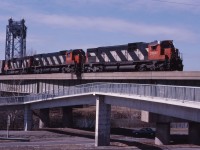 To avoid railway delays, the St. Lawrence Seaway built a double track "diversion" which to allow CN (and now also AMT and VIA) trains to avoid conflicts with marine traffic. Here we see Toronto-Halifax freight 308 with a C630m/M636/C630m lash-up passing over the St. Lambert locks and Riverside Road as it approaches the St. Lambert station where it will receive train order for its run to Joffre Yard.