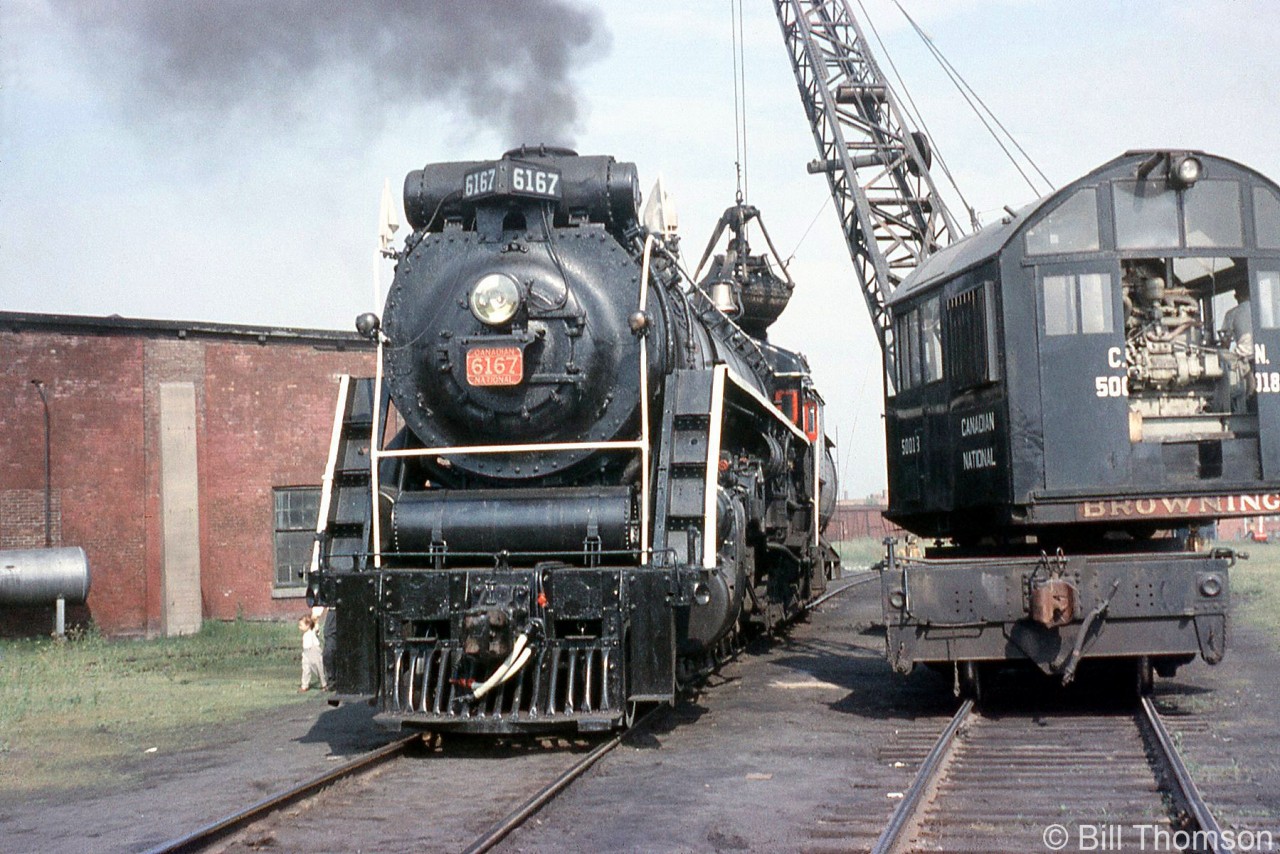 In the absence of proper fueling facilities for steam power, especially later on in the diesel era, cranes or other means were often employed to "refuel" steam engines on excursion stops. CNR Northern 6167, operating on a UCRS fantrip from Toronto to Niagara Falls (via Caledona, Welland Jct., Port Robinson and Stamford), takes on coal from CN Browning crane 50018 by the roundhouse at Niagara Falls, Ontario, on July 10th 1960.