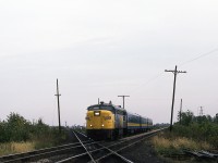 FPA-4 6791 with a typical mid-week consist of 3 coaches as it glides across the CPR Windsor Subdivision a few miles west of downtown Chatham. The old round city water tower and the Wheels Inn resort are in the far left background, beyond 'Ringold' siding on CP. The MLW's days are numbered, as the first order of F40's is about 45 days away from being delivered.