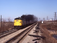 
April 1, 1984. ( the day singer Marvin Gay died). But for me, just another day of hanging out at the CN + CP diamond west of Chatham. I lived on the near west side of the city, so it was only a 10 minute drive to get here. I only made the effort on days that were sunny and clear from humidity. I would also only spend time when certain passenger trains were scheduled because I knew the F40's were going to be purchased, and I wanted to get the cab units in their twilight. On this Sunday, I waited for train 75 to appear in the distance, then I hastily climbed to the first-level perch of the eastward Absolute signal and grabbed this image as the A-B pair of MLW's throttled up again. 