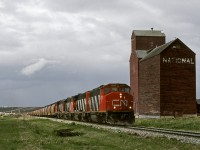 CN's Rycroft turn returning to Grande Prairie passes a derelict elevator as a storm brews in the north